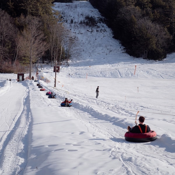 People in tubes being pulled up the sled hill.